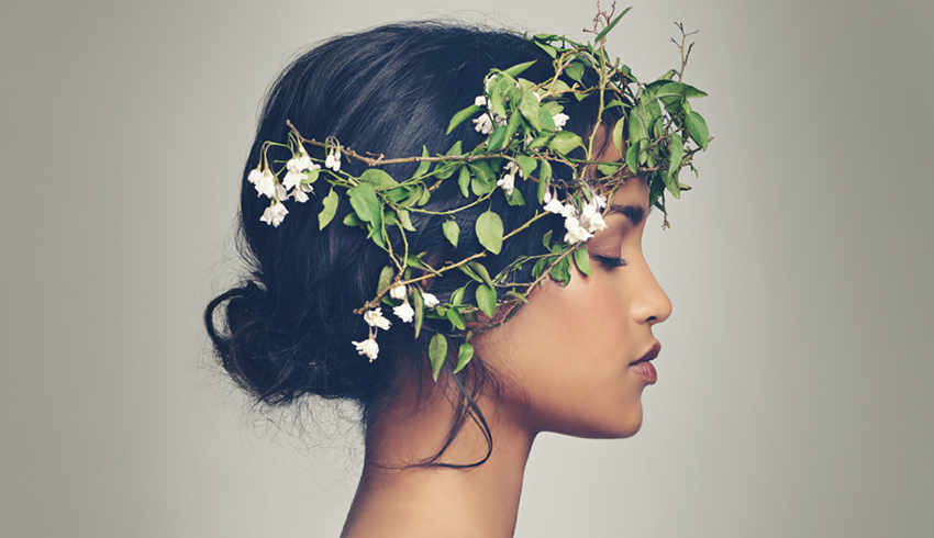 The side profile of a woman wearing a crown of flowers